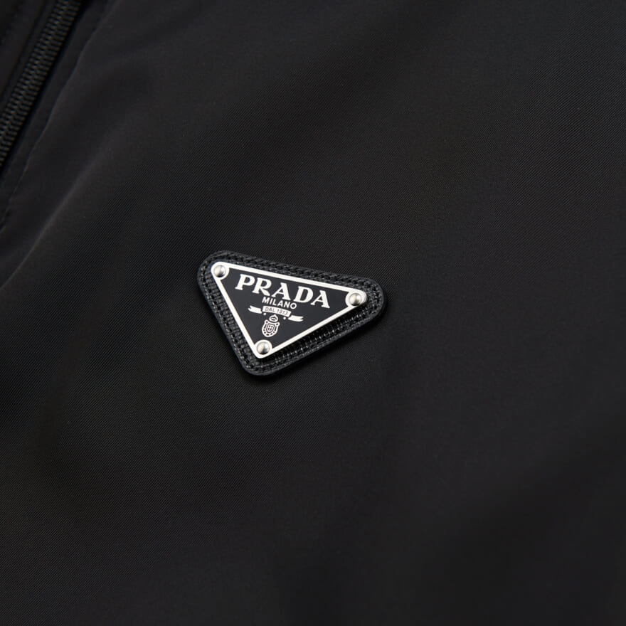 プラダの２３年新作黒ダウン 「Re-Nylon ダウンジャケット」のトライアングルロゴ