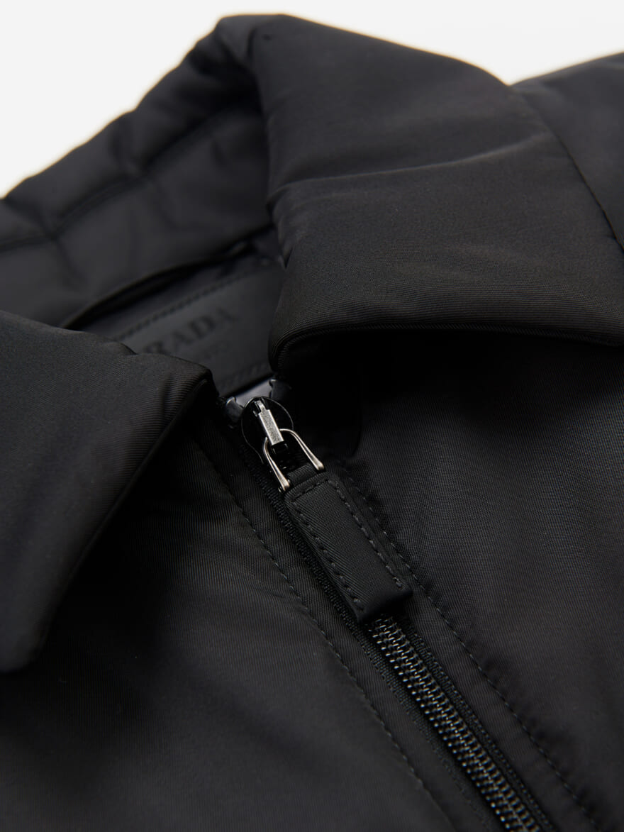 プラダの２３年新作黒ダウン 「Re-Nylon ダウンジャケット」の襟元とジップのディテール