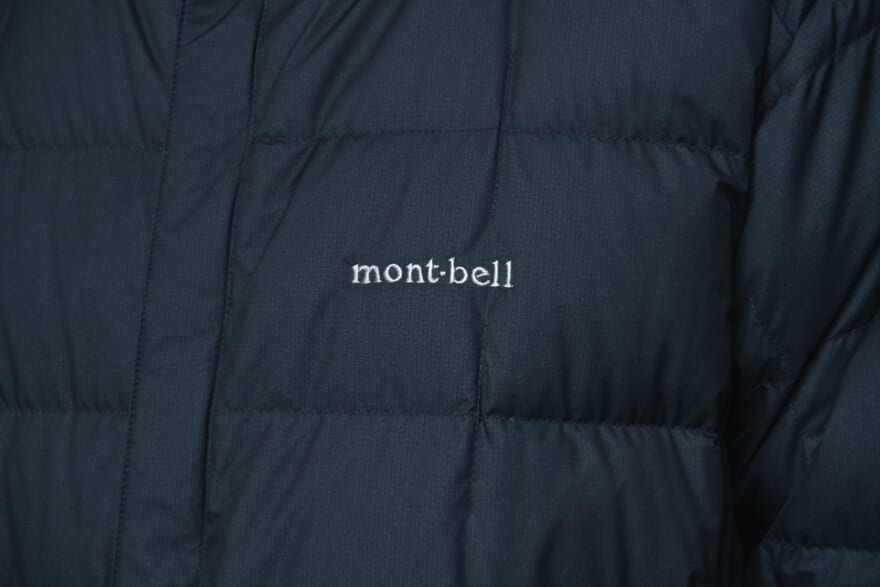 モンベルの黒ダウン「U.L.トラベルダウン コート」の着用カット　ロゴ