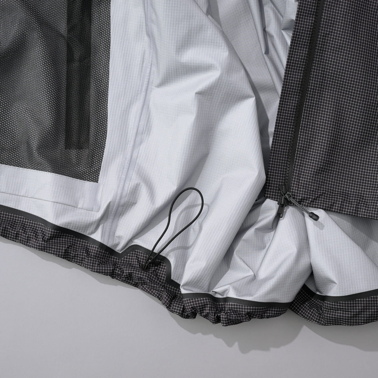 スタイリストオススメのザ・ノース・フェイスの黒いレインジャケット　THE NORTH FACE “Enride Rain Jacket”　裾のコード